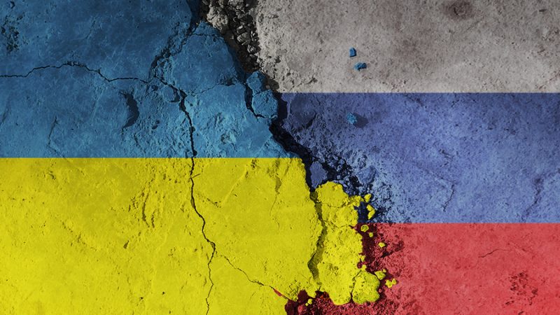 Russia-Ukraine Flags painted on a crumbling wall